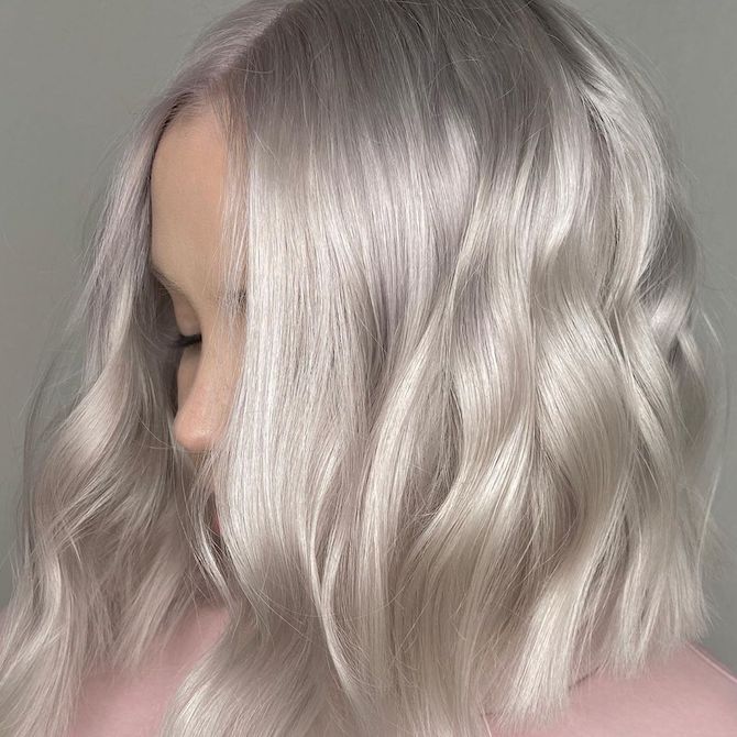 Side profile of woman with short, wavy, ice blonde hair, created using Wella Professionals.