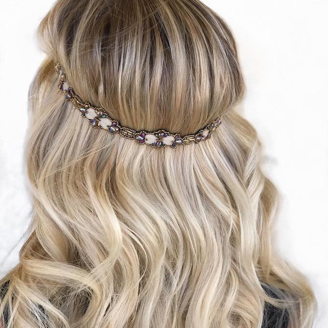 Back of woman’s head with long, wavy, blonde hair and boho band.
