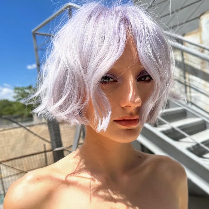 Model with pastel purple, chin-length bob haircut.