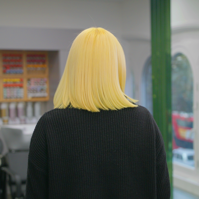 Woman with bright neon yellow straight blunt cut bob