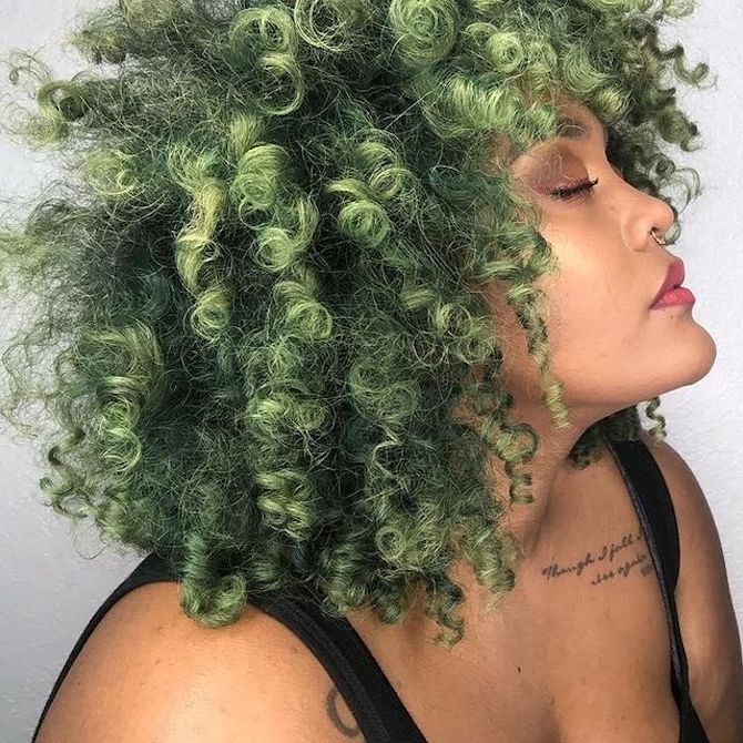 Profile of woman with glossy, curly, ash green hair, created using Wella Professionals.