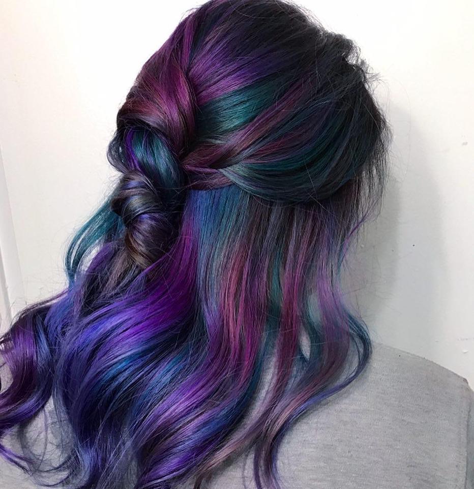 Woman with rainbow hair, half up half down hair styled with loose waves