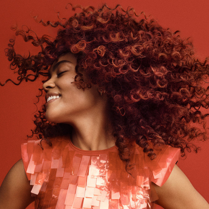 Model curly, cherry cola-coloured hair.