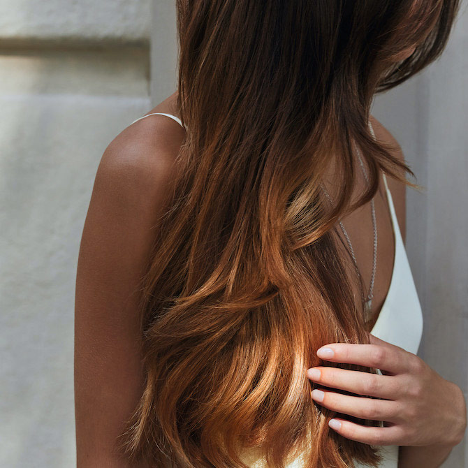 Close-up of model’s shoulder with hair flowing past it.