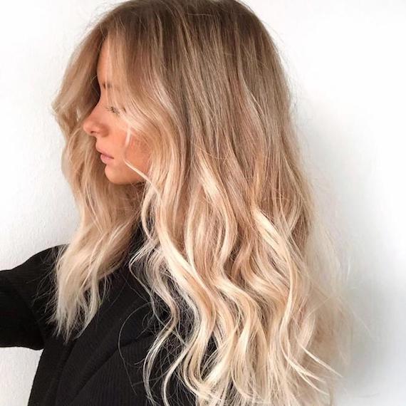 Seitliches Profilfoto von einer Frau mit blondem Haar mit Foilyage-Effekt, kreiert mit Wella Professionals