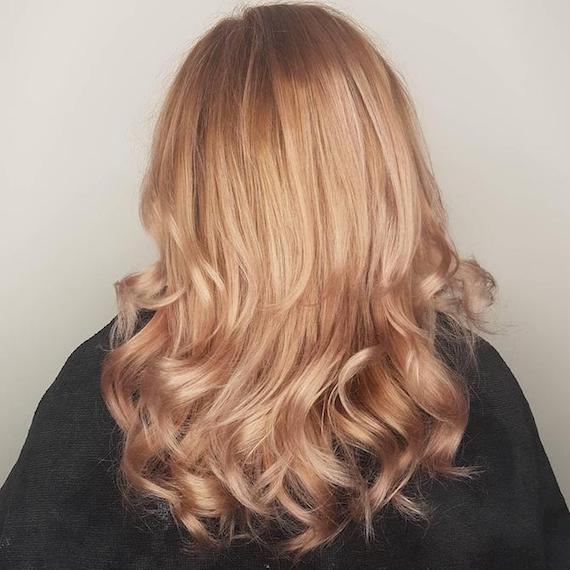 Photo of the back of a woman’s head with wavy champagne blonde hair, created using Wella Professionals
