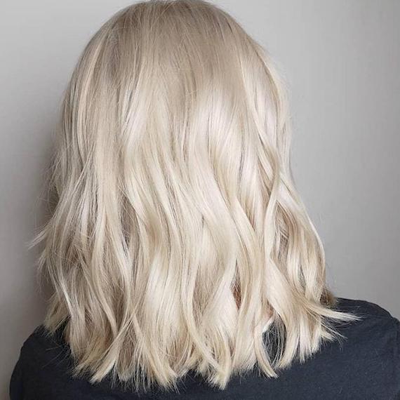 Photo of the back of a woman’s head with wavy cream blonde hair, created using Wella Professionals