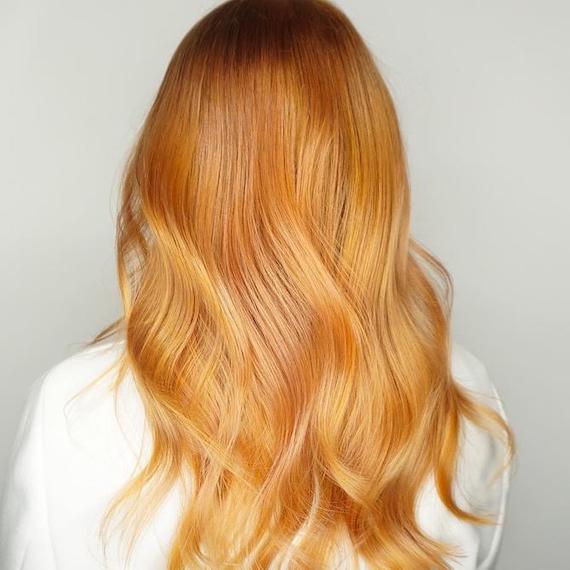 Back of woman’s head with long, pale strawberry blonde hair. 