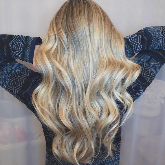 Back of woman’s head with long, wavy, blonde hair, created using Wella Professionals. 