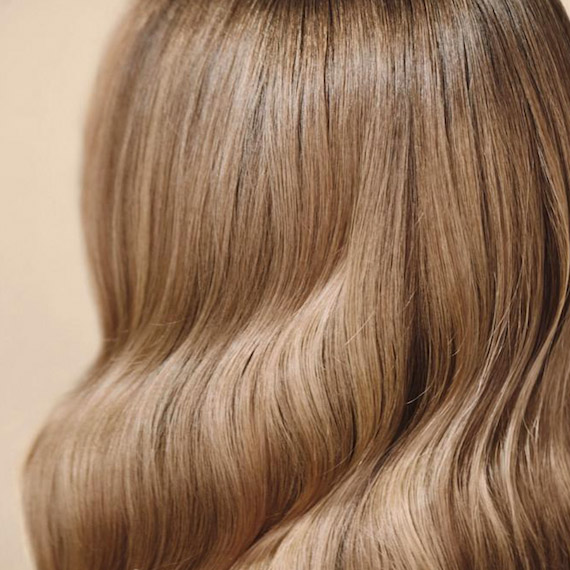 Close-up of wavy, honey-blonde hair coloured using Koleston Perfect Special Blonde by Wella Professionals