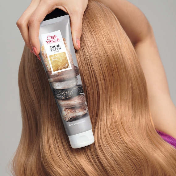 Model with golden blonde, glossy hair holds up Color Fresh Mask in Golden Gloss.