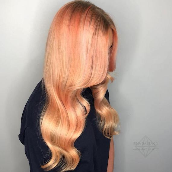 Side profile of model with peach platinum hair.