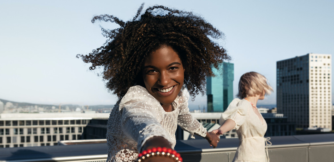 Two women standing on a rooftop in the sun. 