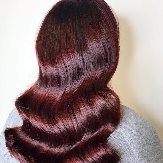 Model with ultra-glossy, merlot red hair. 