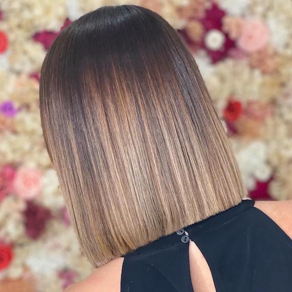 Back of woman’s head with bob haircut featuring caramel ombre.