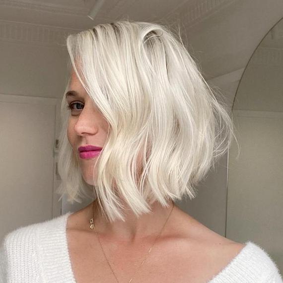 Woman faces the camera with platinum blonde bob haircut.