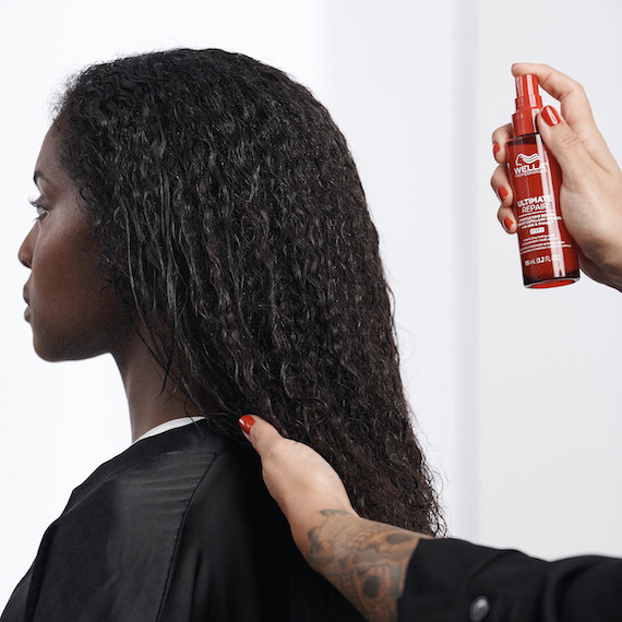 ULTIMATE REPAIR Miracle Hair Rescue is sprayed through model’s long, dark hair.