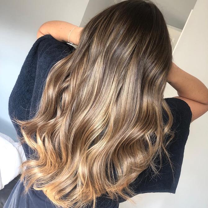 Back of woman’s head with ash brown to ash blonde balayage, created using Wella Professionals.