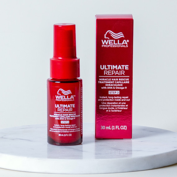 A bottle of Ultimate Repair Miracle Hair Rescue sits on a marble surface.
