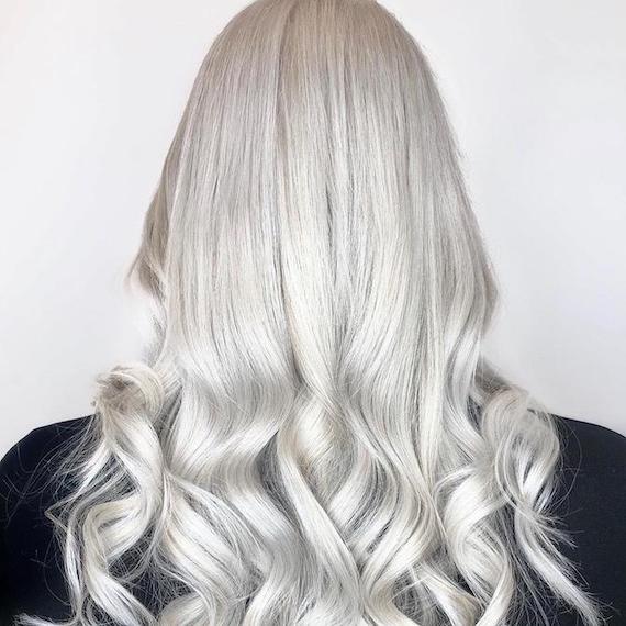 Back of woman’s head with long silver gray hair, created using Wella Professionals. 