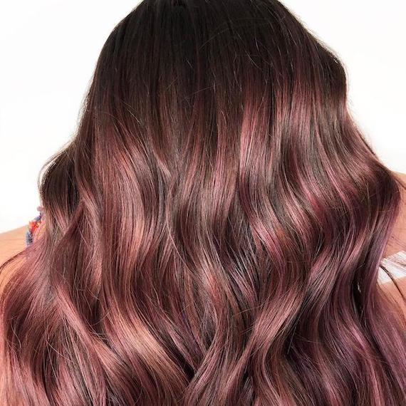 Back of woman’s head with raspberry chocolate, wavy hair, created using Wella Professionals. 