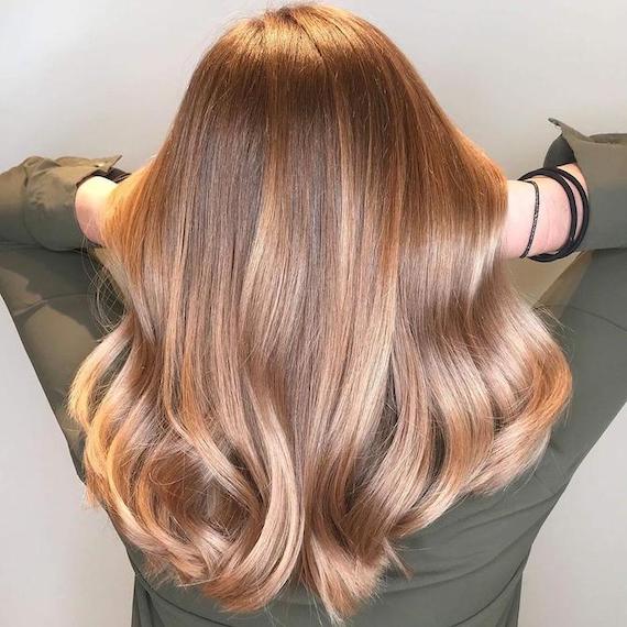 Back of woman’s head with long, glossy, bronde balayage hair, created using Wella Professionals.