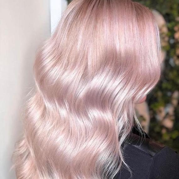 Back of woman’s head with wavy, pastel pink hair, created using Wella Professionals.