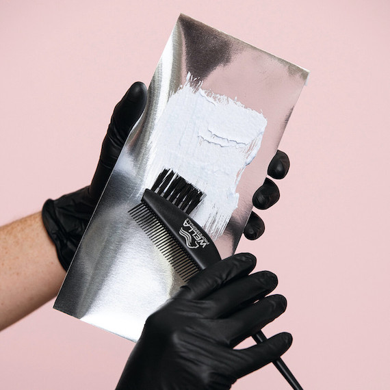 Close-up of hair colour on foil, being picked up with a tint brush.