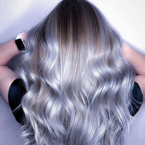 Back of model’s head with long, wavy, light ash blue hair and silver highlights.