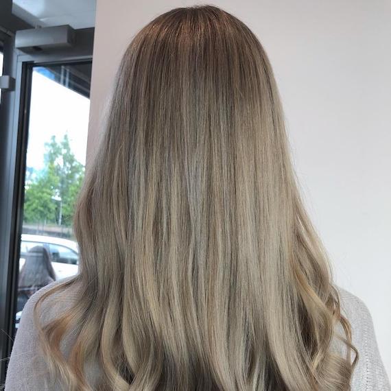 Photo of the back of a woman’s head with grey ash brown hair, created using Wella Professionals.