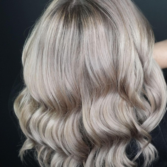 back of woman’s head with wavy, ash gray blonde hair 