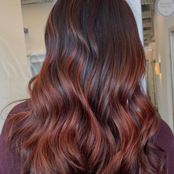 Back of woman’s head with tousled, auburn red hair, created using Wella Professionals.