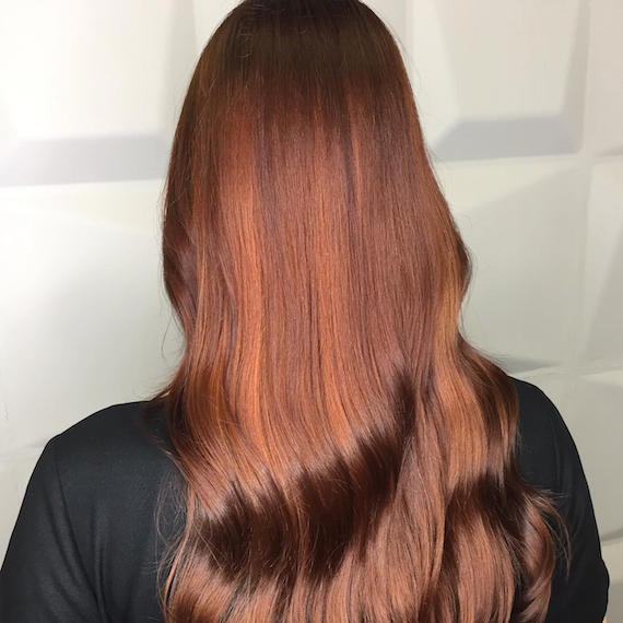 Back of woman’s head with long, wavy, auburn hair and highlights, created using Wella Pro-fessionals.