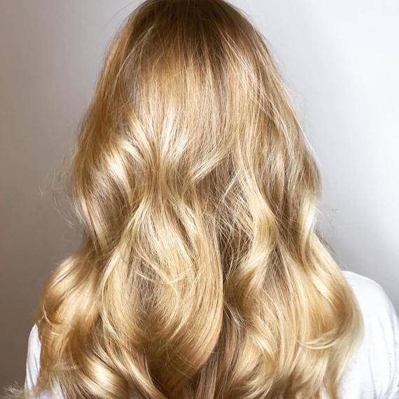 Back of woman’s head with long warm blonde hair and babylights, created using Wella Professionals.