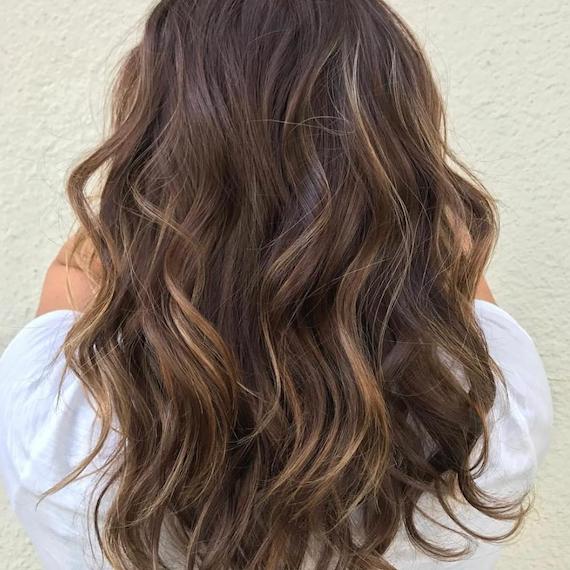 Back of woman’s head with brown hair and babylights, created using Wella Professionals.