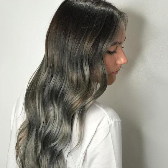 Side profile of woman with long, wavy, silver hair, created using Wella Professionals.