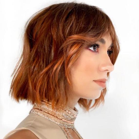 Photo of woman with wavy copper balayage bob, created using Wella Professionals.