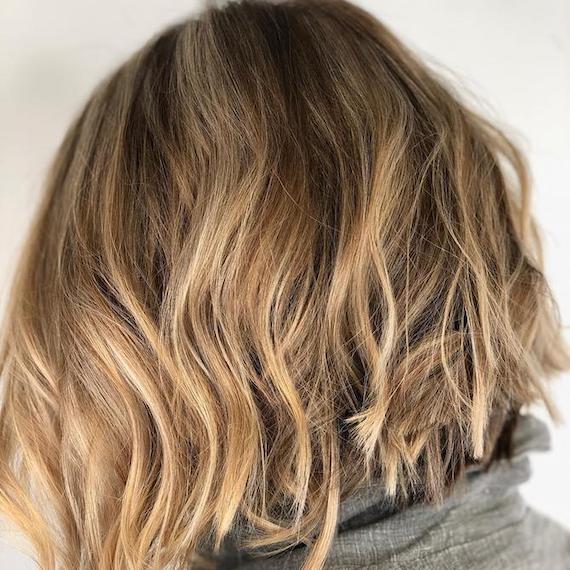 Back of woman’s head with beachy blonde balayage through a bob, created using Wella Professionals.