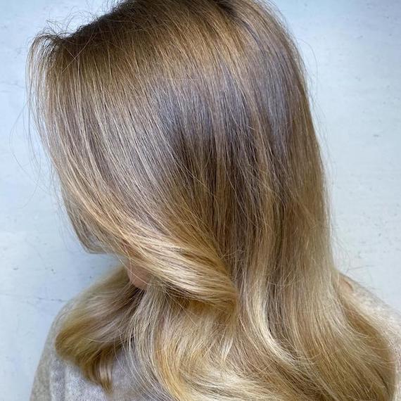 Side profile of woman with balayage blowdry, created using Wella Professionals.