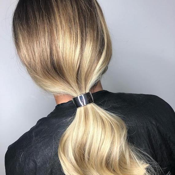 Back of woman’s head with blonde, balayage ponytail, created using Wella Professionals.