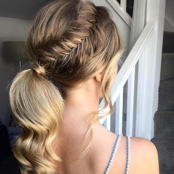 Back of woman’s head with blonde, balayaged fishtail braid, created using Wella Professionals.