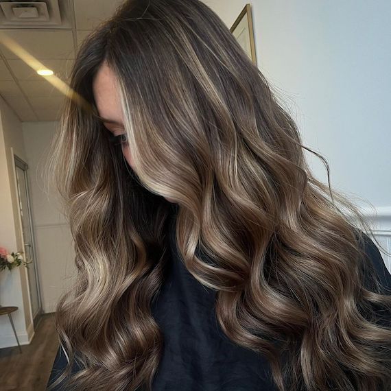 Model with long, ash brown hair and an ash blonde balayage.