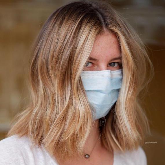 Woman facing camera with shoulder-length, beachy blonde hair, created using Wella Professionals.