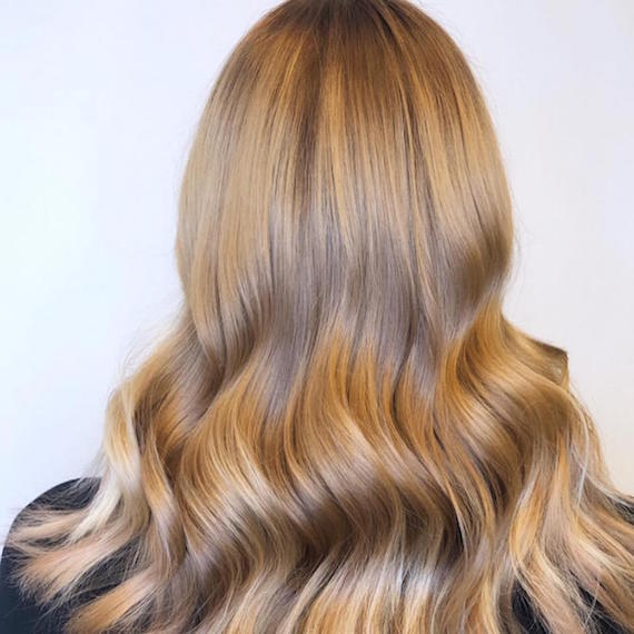 Back of woman’s head with medium beige blonde hair, created using Wella Professionals.