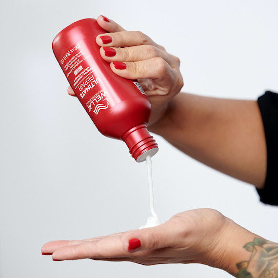 ULTIMATE REPAIR Shampoo is poured into a hairdresser’s hand.