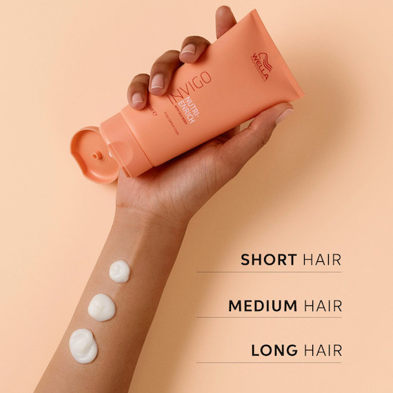Hand holding Nutri-Enrich Frizz Control Cream, with swatches showing how much to use. 