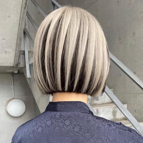 Back of woman’s head with blunt black and blonde bob, created using Wella Professionals.