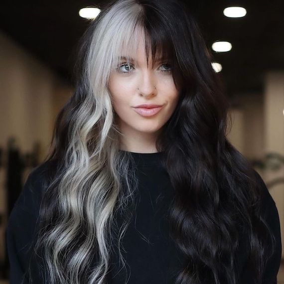 Model with long, wavy black hair, featuring a silver color block on one side.