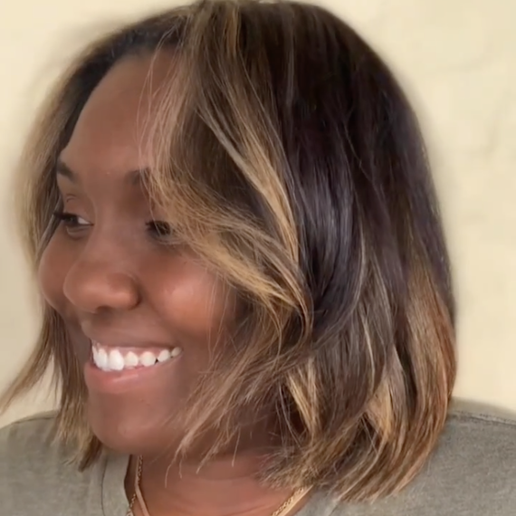 Side profile of model with black bob haircut and blonde face-framing highlights.