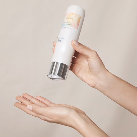 Wella ColorMotion+ Color Protection Shampoo is poured into the palm of a hand.